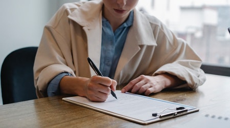 A young women filling out a job application on a clipboard