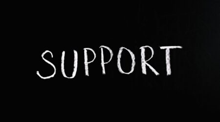 The word "support" written in white chalk on a black background