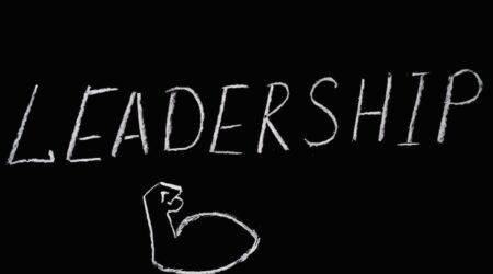 "Leadership" written on a blackboard and a drawing of a muscle