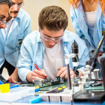 A group of people work on electronics